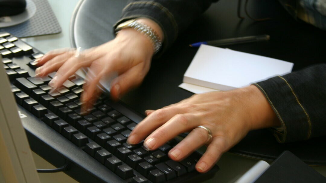 Hände tippen schnell auf einer Tastatur