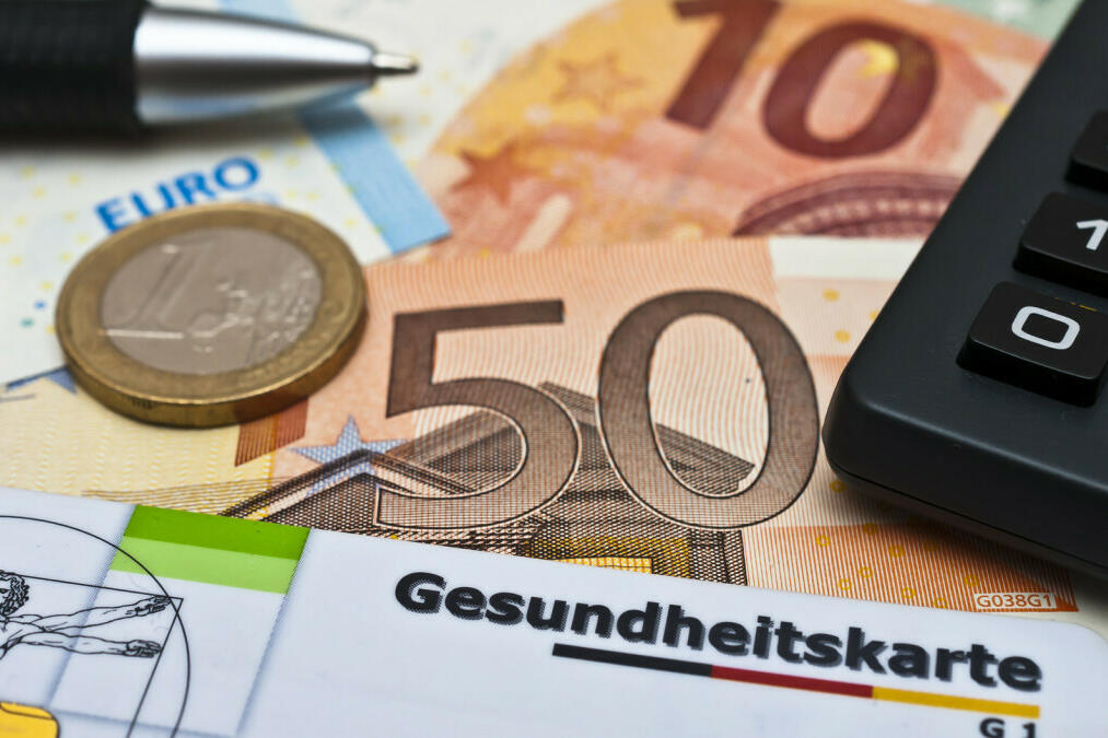 2 Geldscheine, eine Münze und eine Gesundheitskarte sind zu sehen