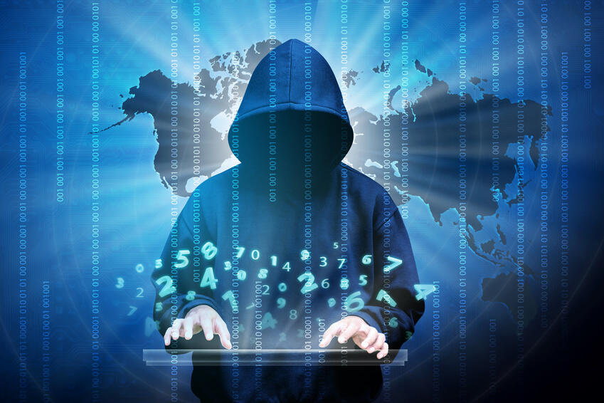 Düster aussehender Mensch vor Weltkarte tippt auf einem Laptop und Zahlen schwirren durch die Luft.